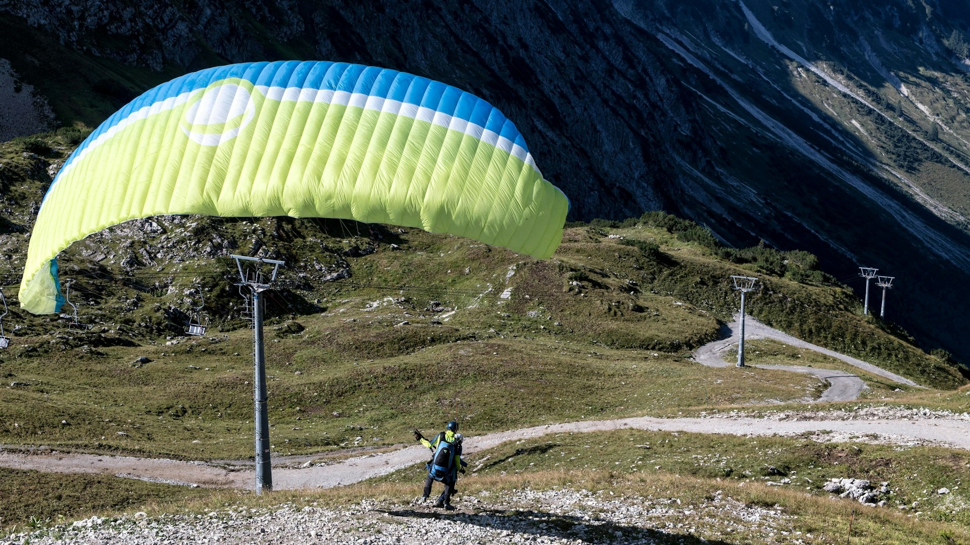 Gleitschirmflieger startet vor Alpenpanorama im Allgäu