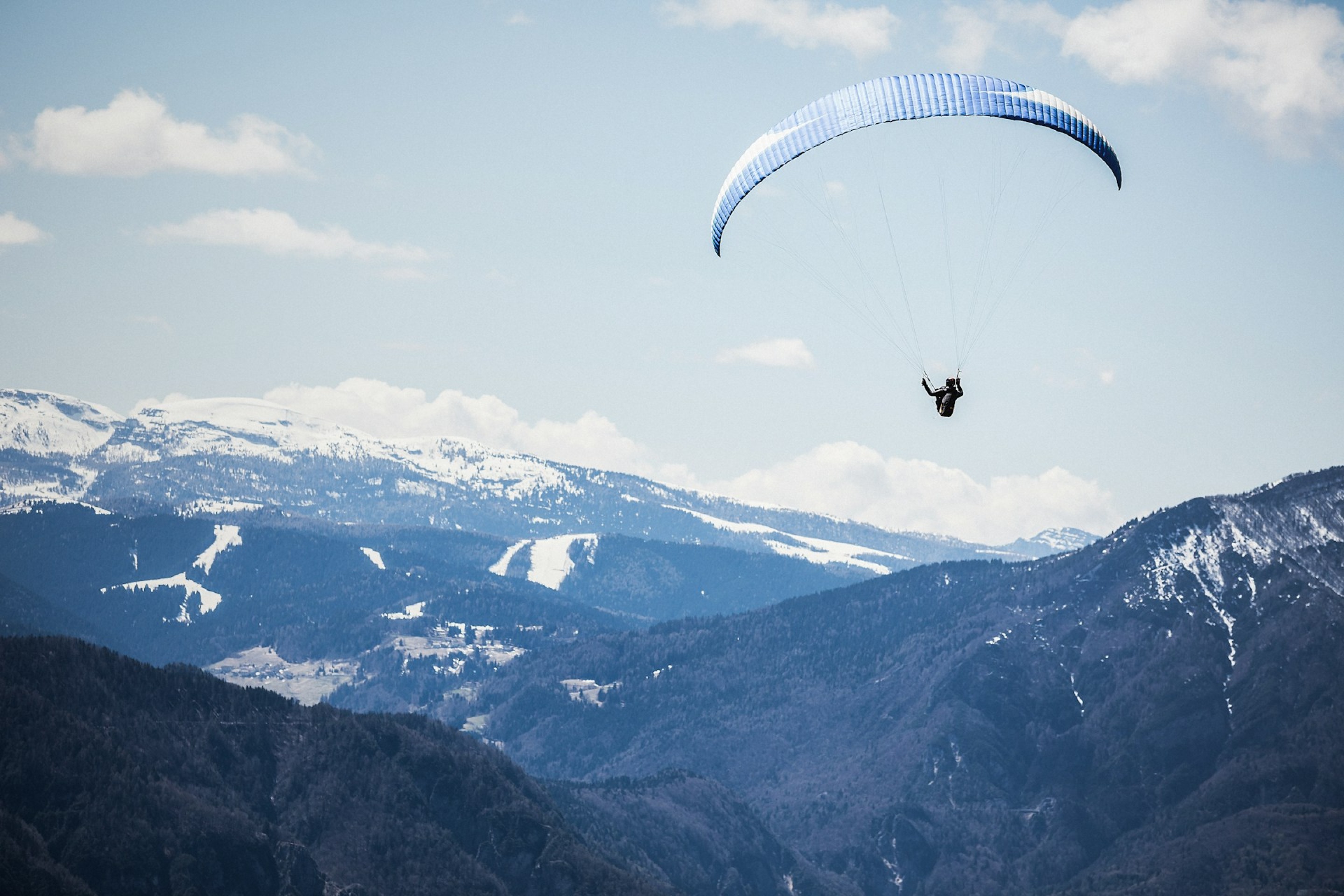 Gleitschirmpilot fliegt über traumhafte Berglandschaft